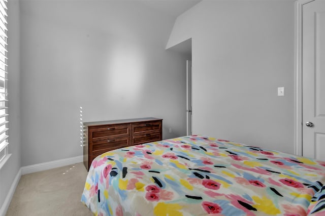 bedroom with light carpet and baseboards