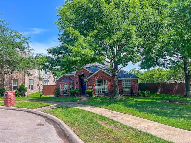 view of front facade with fence, a front lawn, and brick siding
