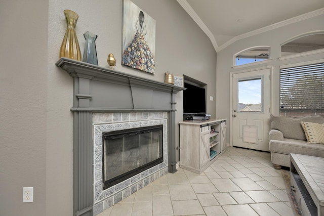 living area featuring ornamental molding, light tile patterned floors, lofted ceiling, and a tile fireplace