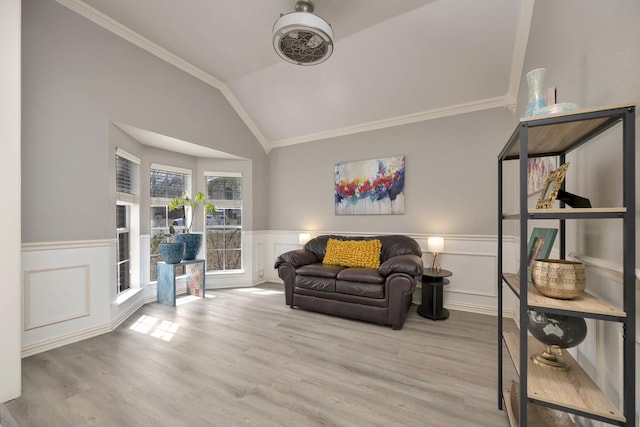 sitting room featuring wainscoting, ornamental molding, wood finished floors, and lofted ceiling