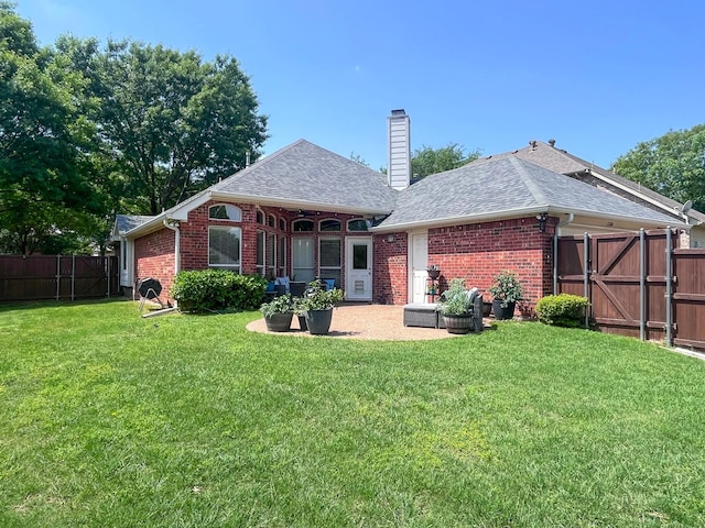 rear view of house with a shingled roof, a chimney, and brick siding