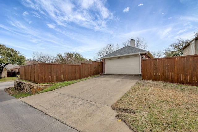 view of home's exterior with concrete driveway, brick siding, fence, and a chimney