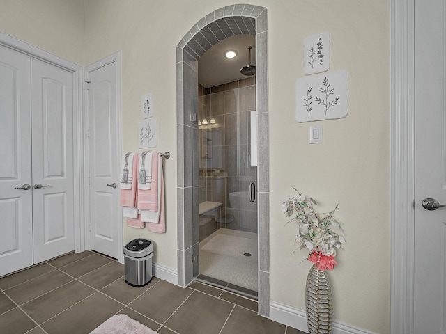 bathroom with tile patterned flooring, baseboards, and a stall shower