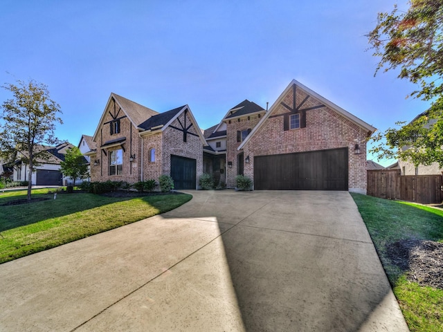 view of front of house with fence, an attached garage, a front lawn, concrete driveway, and brick siding