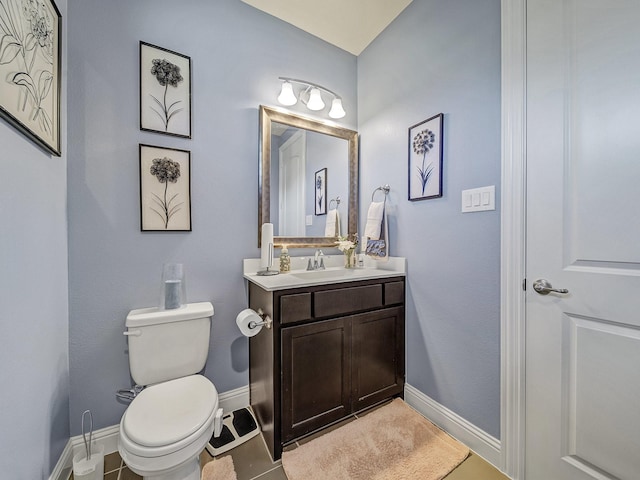 bathroom featuring baseboards, toilet, vanity, and tile patterned flooring