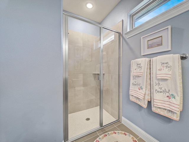 bathroom with tile patterned floors, baseboards, and a stall shower