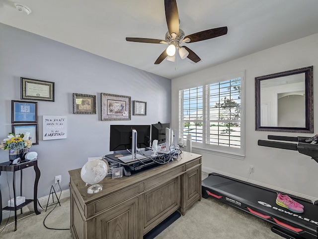 home office featuring light carpet, baseboards, and ceiling fan