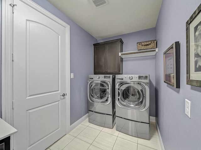 clothes washing area featuring independent washer and dryer, cabinet space, visible vents, and baseboards