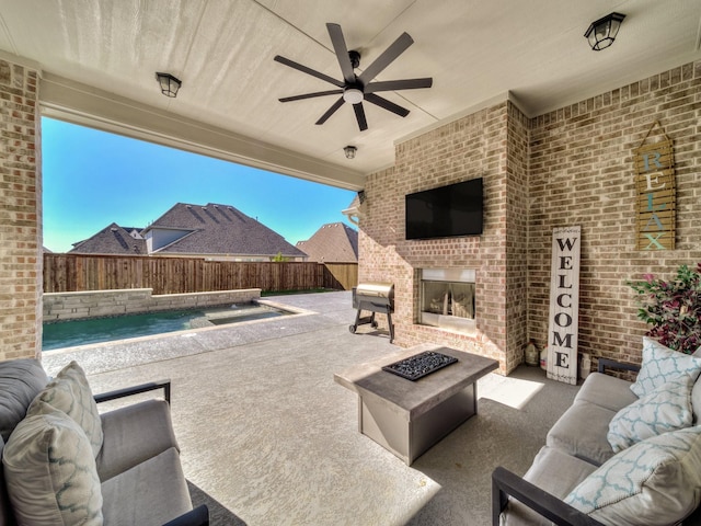 view of patio / terrace featuring ceiling fan, a fenced in pool, a fenced backyard, and an outdoor living space with a fireplace