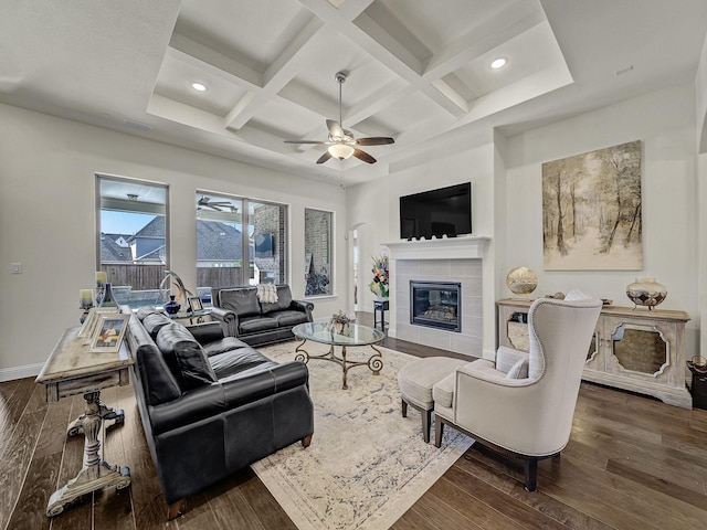 living area featuring coffered ceiling, baseboards, a ceiling fan, and wood finished floors