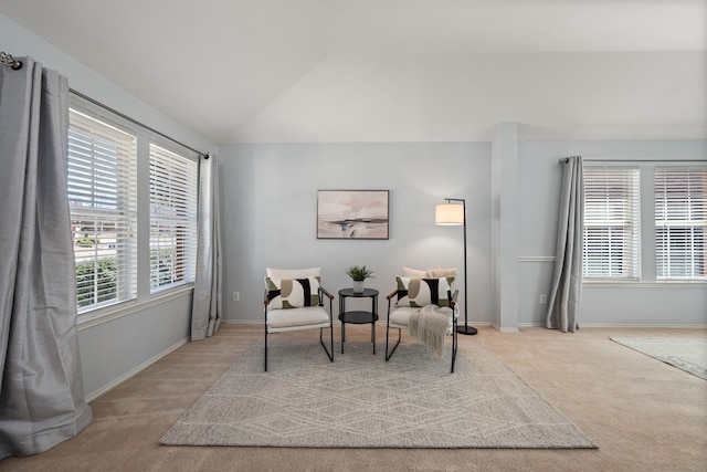 sitting room featuring light colored carpet, baseboards, and lofted ceiling