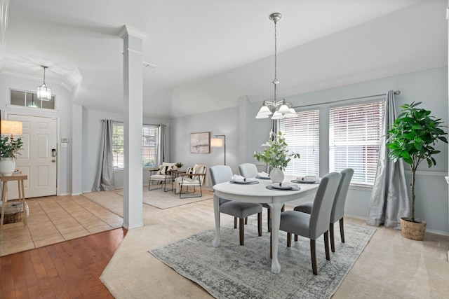 dining room with visible vents, a notable chandelier, baseboards, decorative columns, and lofted ceiling