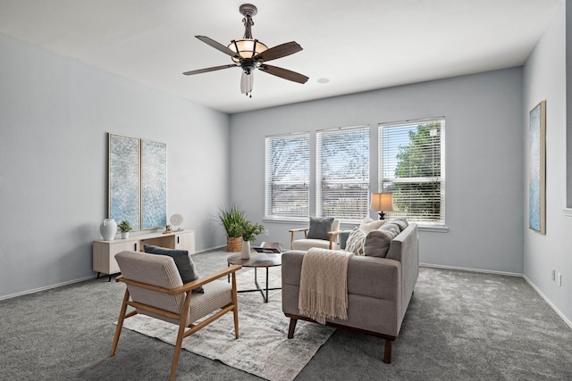 carpeted living area featuring baseboards and a ceiling fan