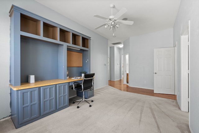 office space with visible vents, built in study area, carpet, and a ceiling fan