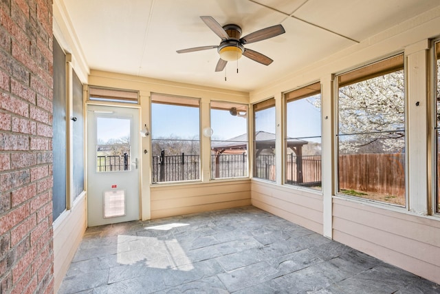 unfurnished sunroom featuring ceiling fan