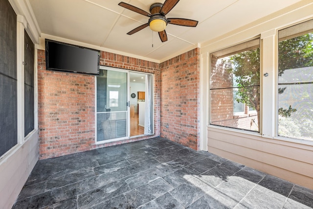 unfurnished sunroom with a healthy amount of sunlight and a ceiling fan