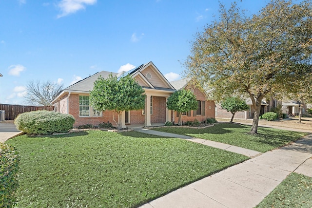 view of front of house featuring a front yard, fence, and brick siding