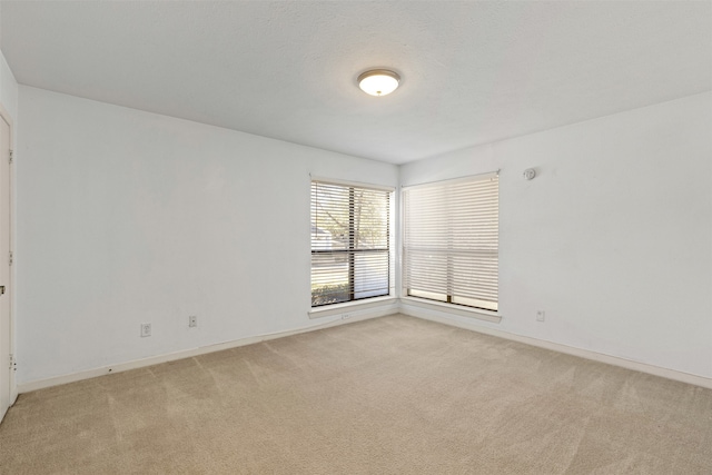 empty room with light colored carpet and baseboards