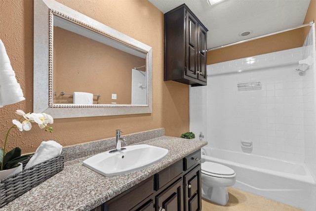 bathroom featuring vanity, bathing tub / shower combination, toilet, and a textured wall