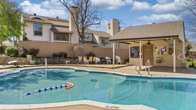 view of swimming pool with an outdoor structure, fence, a fenced in pool, and a patio area