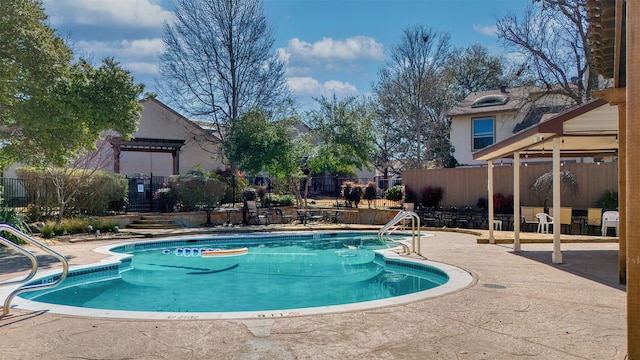 community pool featuring a patio and fence