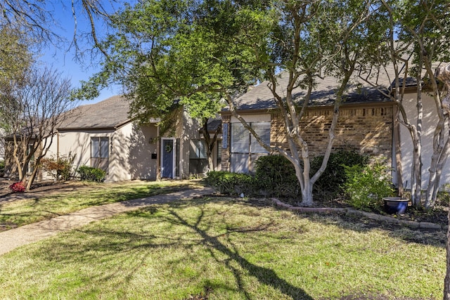 view of front of home featuring stucco siding and a front yard