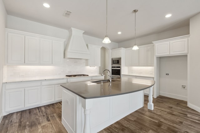 kitchen featuring premium range hood, dark wood-style flooring, a sink, stainless steel appliances, and white cabinetry