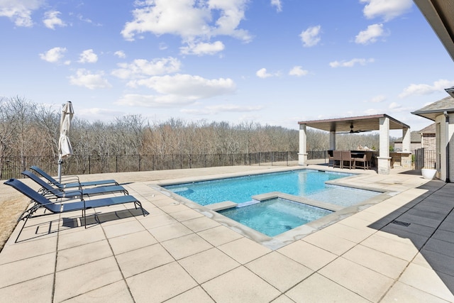 view of pool with a patio, fence, and a pool with connected hot tub