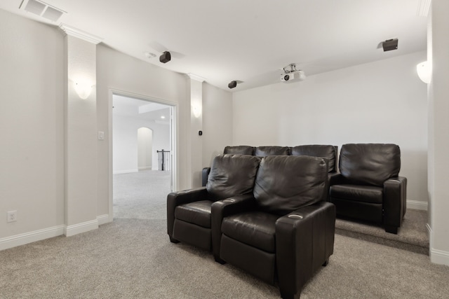 cinema room featuring arched walkways, visible vents, carpet flooring, and baseboards