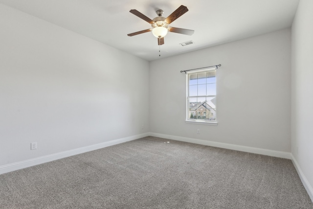 carpeted empty room with baseboards, visible vents, and ceiling fan