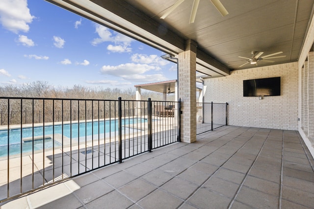 view of patio with an in ground hot tub, fence, a ceiling fan, and a fenced in pool