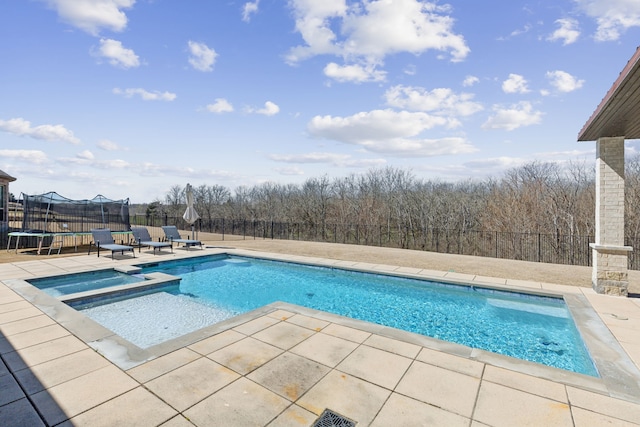 view of pool with a patio, a trampoline, a fenced backyard, and a pool with connected hot tub