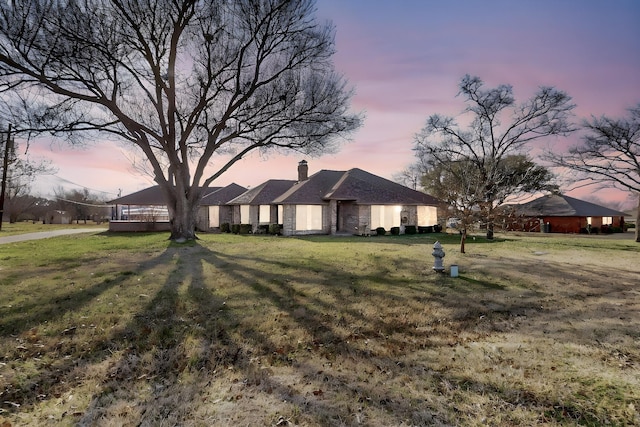 single story home with a chimney and a front yard