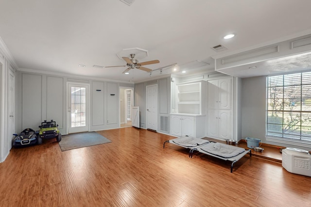 interior space with a decorative wall, plenty of natural light, wood finished floors, and visible vents