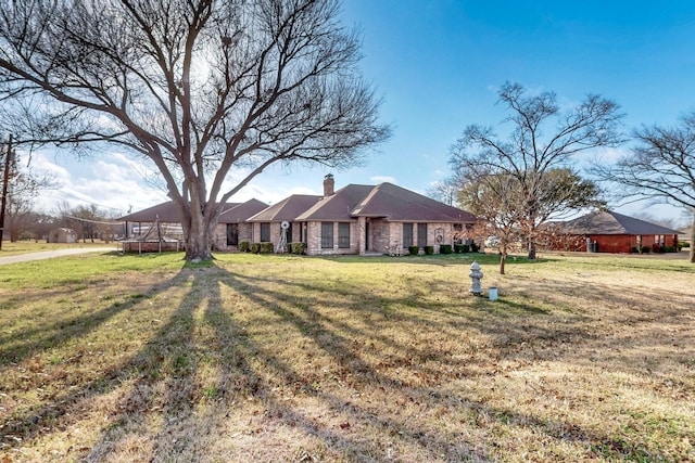 single story home featuring a chimney and a front yard