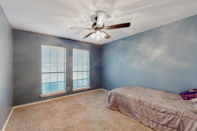 carpeted bedroom with a ceiling fan and baseboards