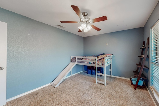 carpeted bedroom featuring visible vents, a ceiling fan, and baseboards