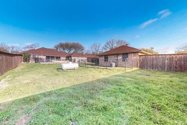 view of yard with central AC unit and a fenced backyard