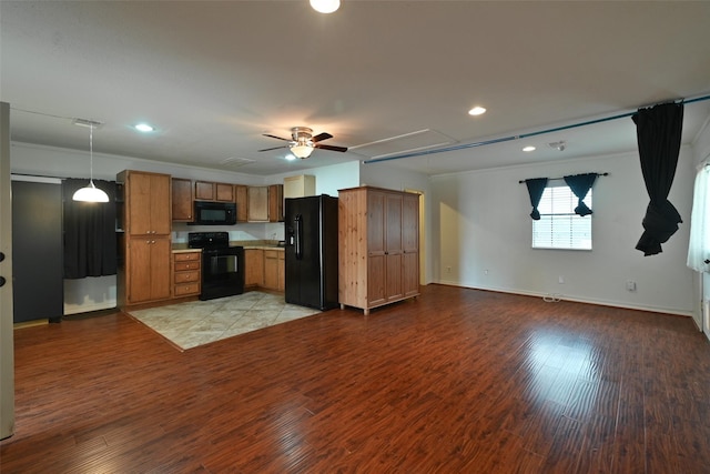 kitchen with brown cabinets, black appliances, light countertops, light wood-style floors, and open floor plan