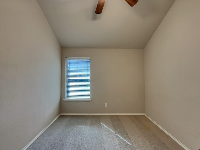 carpeted spare room featuring baseboards, lofted ceiling, and ceiling fan