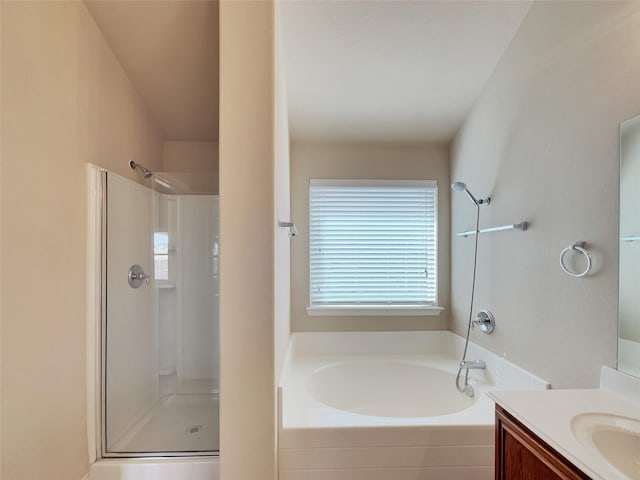 bathroom featuring a stall shower, vanity, and a garden tub