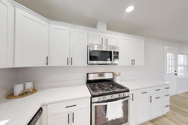 kitchen featuring recessed lighting, stainless steel appliances, light wood-style flooring, and white cabinetry