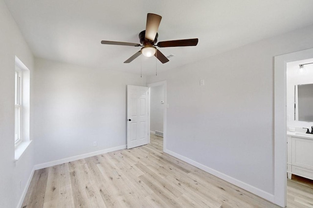 unfurnished room featuring visible vents, baseboards, ceiling fan, light wood-style floors, and a sink