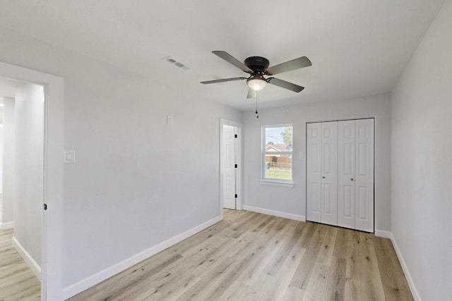 unfurnished bedroom with light wood-type flooring, visible vents, a closet, baseboards, and ceiling fan