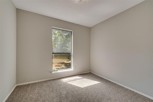 spare room featuring carpet flooring and baseboards