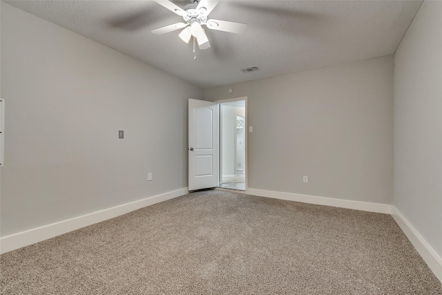 empty room featuring light colored carpet, a ceiling fan, baseboards, and a textured ceiling