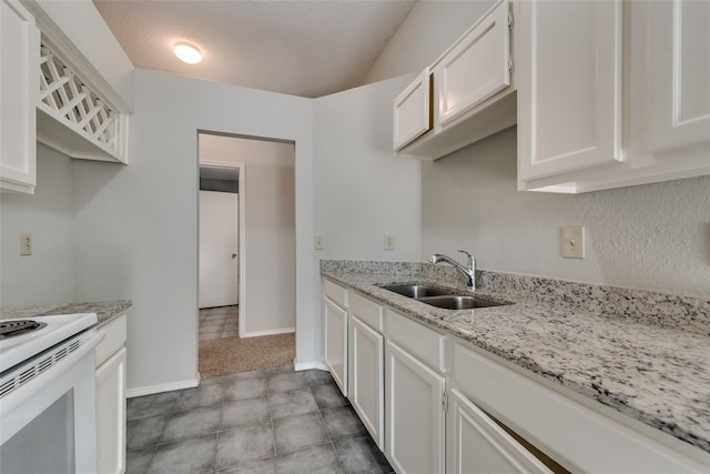 kitchen featuring a sink, white cabinetry, light stone countertops, electric stove, and baseboards