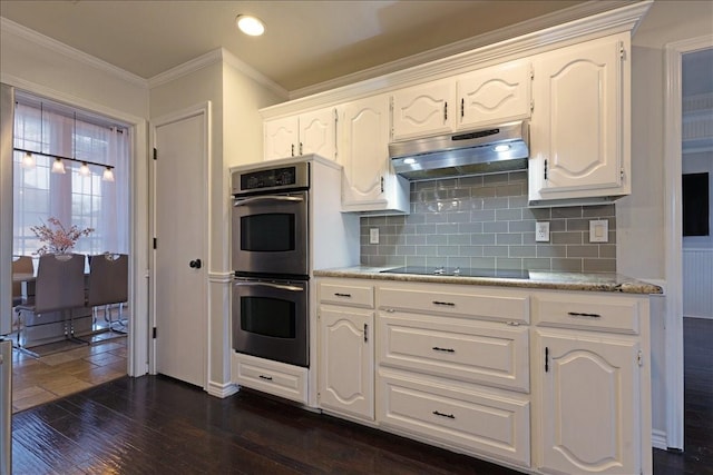 kitchen featuring ornamental molding, under cabinet range hood, double oven, black electric cooktop, and dark wood-style flooring