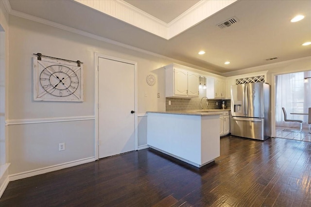 kitchen with visible vents, dark wood-type flooring, a peninsula, stainless steel fridge with ice dispenser, and crown molding