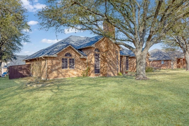 view of front facade with a chimney and a front lawn